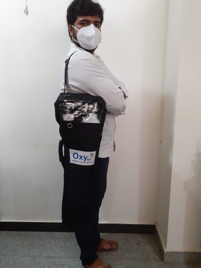 Person carrying aluminum oxygen cylinder